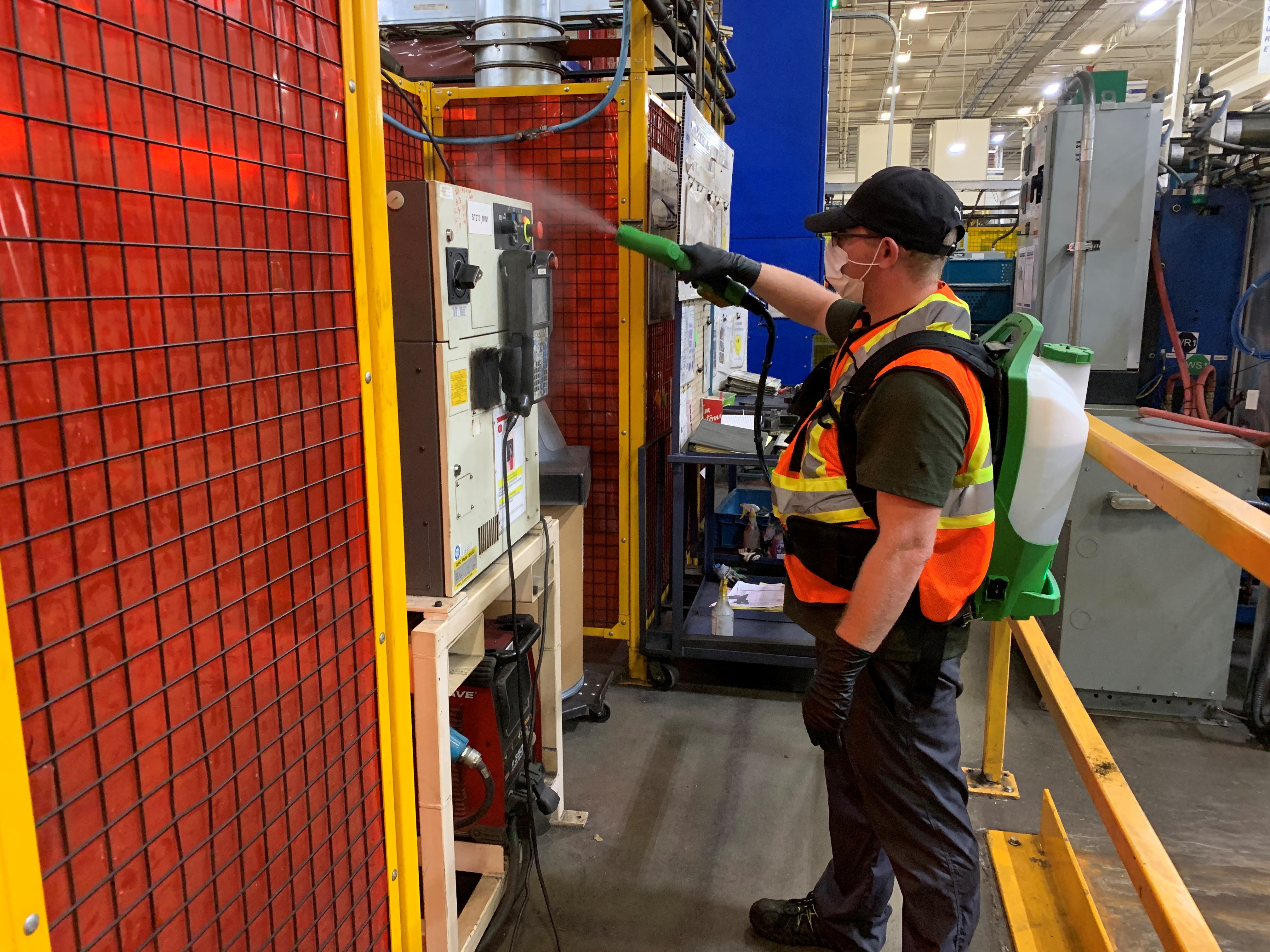 A man is disinfecting a manufacturing facility.