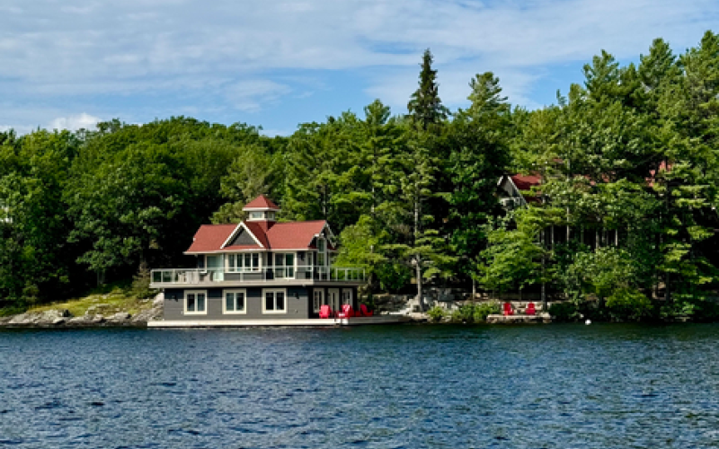 Boathouse in Muskoka surrounded by coniferous and deciduous trees.