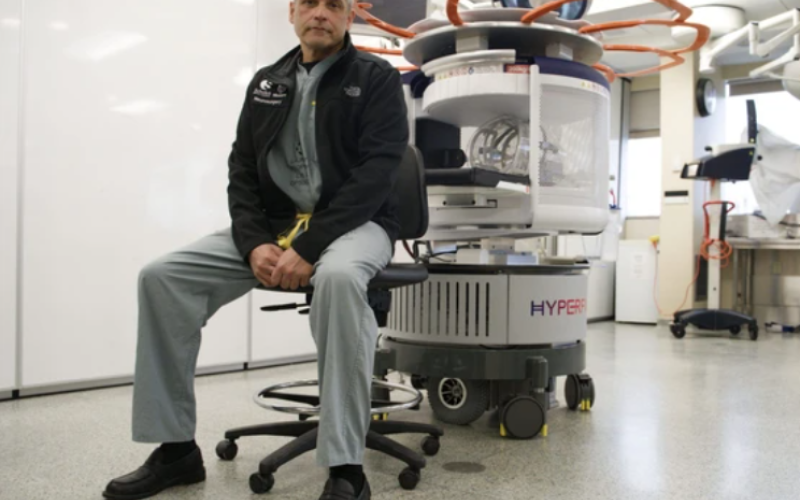 Dr. Neil Duggal, a neurosurgeon at London Health Sciences Centre, sits beside a Hyperfine Swoop portable brain MRI, which LHSC says was used for the first time in the world during surgery to remove a pituitary tumour. Photo taken Friday, March 6, 2026. (Jonathan Juha/The London Free Press)