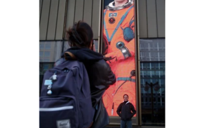 A young man gets his photo taken under a massive picture of Canadian astronaut Jeremy Hansen following the launch of Artemis II. Hundreds gathered outside the National Arts Centre in Ottawa to watch the launch on Wednesday April 1, 2026. (Julie Oliver/Postmedia Network)