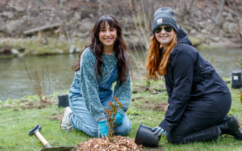 The ‘Campus as a Living Lab’ program has transformed Western's campus into a dynamic hub for sustainability research, one of many green efforts at the university. (L to R) Student Katarina Kukolj and staff member Laura Mantz, engagement coordinator in the Office of Sustainability, plant native species on campus along the banks of Medway Creek. (Steven Anderson/Western Communications)