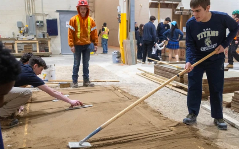 Avery Ritchie of RMC tries his hand at making a clean cut between two sections of sidewalk, with sand used to simulate concrete, during a Trades Awareness Day event for high school students in London on Friday, May 22, 2026. (Mike Hensen/The London Free Press)