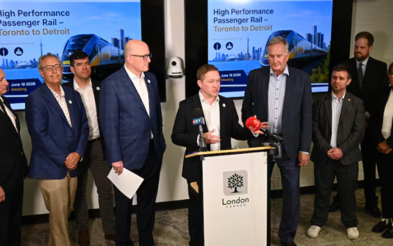 London Mayor Josh Morgan speaks at a news conference calling for high performance passenger rail in southwestern Ontario at London city hall on June 18, 2026. Standing alongside, from left to right: Tim Fischer, Michigan's transportation infrastructure officer; Roger Victory, Michigan state senator; Luke Polcyn, fellow with the Council on Foreign Relations; Drew Dilkens, mayor of Windsor; Kevin Davis, mayor of Brantford; Phil Murphy-Rhéaume, Canadian managing director with the Great Lakes and St. Lawrence C