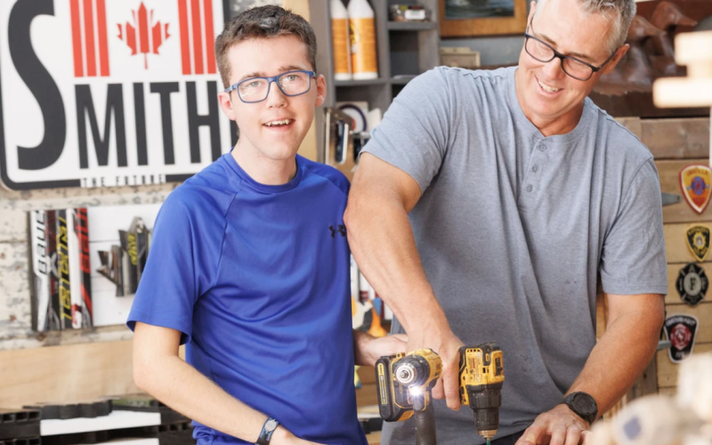 Father and son building hockey stick flags in workshop