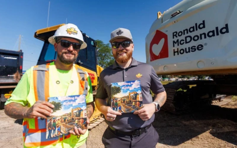 Brad Lalich (left) and Nick Wilton, authors of the children’s book Building Roads, Building Hope, pose with the book during the announcement of J-AAR’s fundraising campaign for Ronald McDonald House Charities Southwestern Ontario in London on Wednesday, July 29, 2026. (Geoff Robins/The London Free Press)