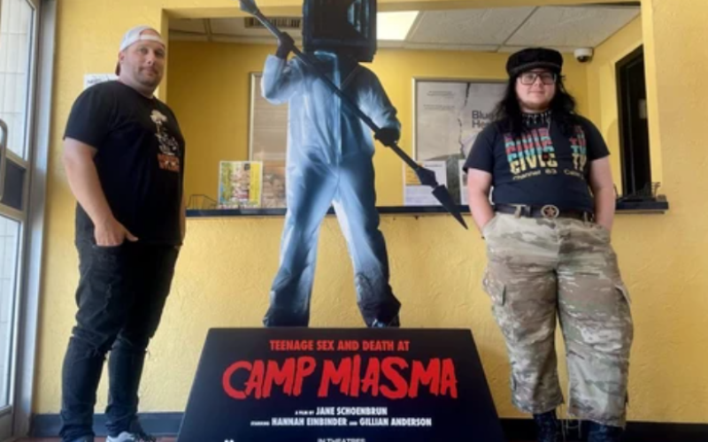 Hyland Cinema manager and programmer Mike Klassen, left, and assistant manager and programmer Raine Petrie pose beside a sign promoting Teenage Sex and Death at Camp Miasma on Monday, Aug. 3, 2026. (Ryan Goodison/The London Free Press)