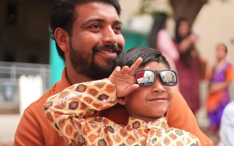 Dave Mathew, 3, adjusts his sunglasses while sitting with his father, Akhil Mathew, at Utsavam Onam Carnival on Dundas Place in London on Saturday, Aug. 1, 2026. (Matthew Daldalian/ The London Free Press)