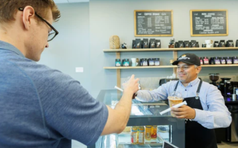 Owner Fabian Ospina presents customers with their order at Almore Coffee on Richmond Street in London on Thursday, Aug. 20, 2026. (Geoff Robins/The London Free Press)
