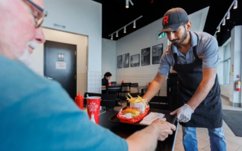 Franchise owner Sourabh Gohad presents a customer his order at Rudy in White Oaks Mall in London, on Tuesday, Aug. 25, 2026. (Geoff Robins/The London Free Press)