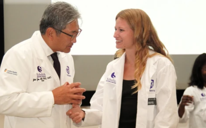 Dr. John Yoo, left, dean of Western University’s Schulich School of Medicine and Dentistry, speaks with incoming medical student Hallee Knelson during the school’s white coat ceremony on campus in London on Thursday, Aug. 27, 2026. (Matthew Daldalian/The London Free Press)