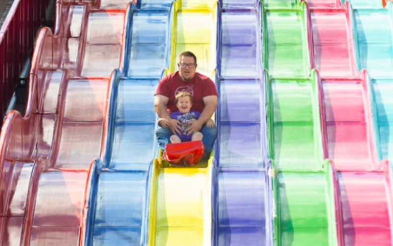 Three year old Charlie Taylor and his father John laugh their way down the Eursoslide on opening day of the Western Fair in London, Ontario on Friday September 5, 2025. (Free Press file photo)