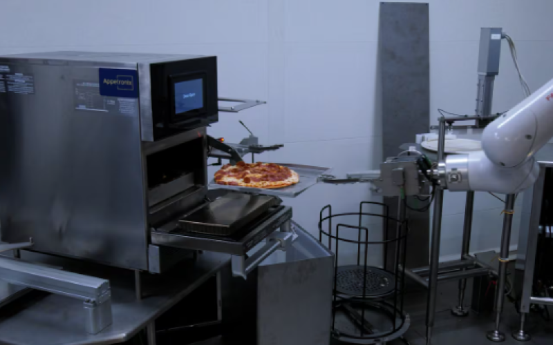 A robot arm removes a robot made pizza from the oven. (Bryan Bicknell/CTV News London)