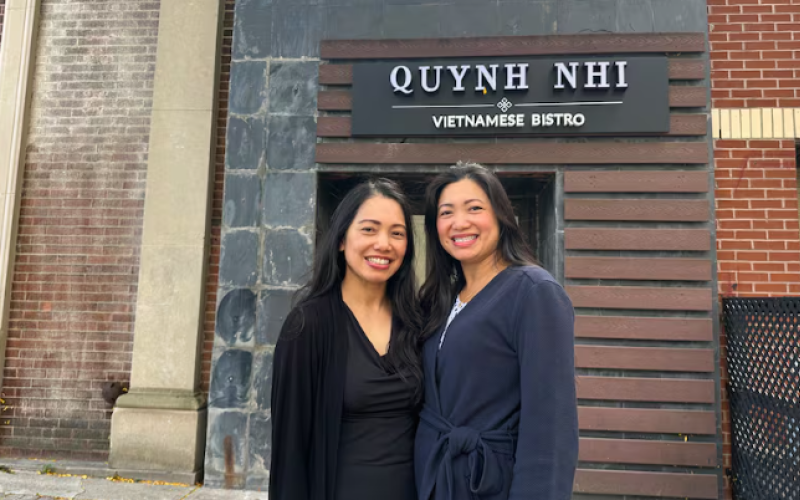 Sisters Quynh and Nhi Pham stand in front of the new location of the restaurant they're re-opening. The takeout entrance is at 127 Carling Street and the dine-in is at 118 Dundas Street in London's downtown. (Kate Dubinski/CBC)